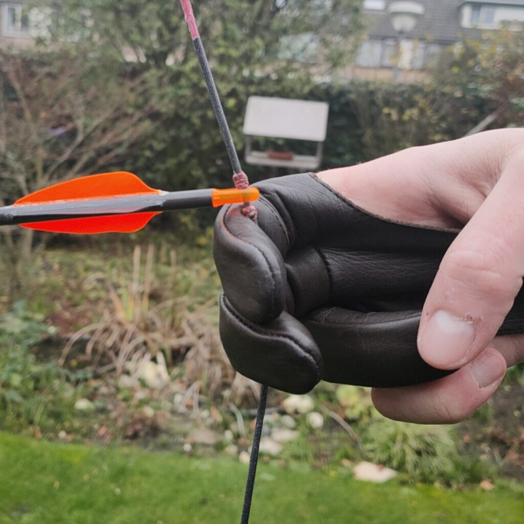 How to hold the bowstring guide with pictures